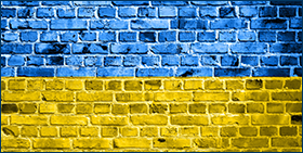Coface Focus: Economische gevolgen van het conflict Rusland-Oekraïne: Stagflatie in het vooruitzicht. Afbeelding van een bakstenen muur met een blauwe en gele overlay die overeenkomt met de nationale vlag van Oekraïne 